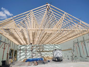 Building under construction featuring roof trusses.